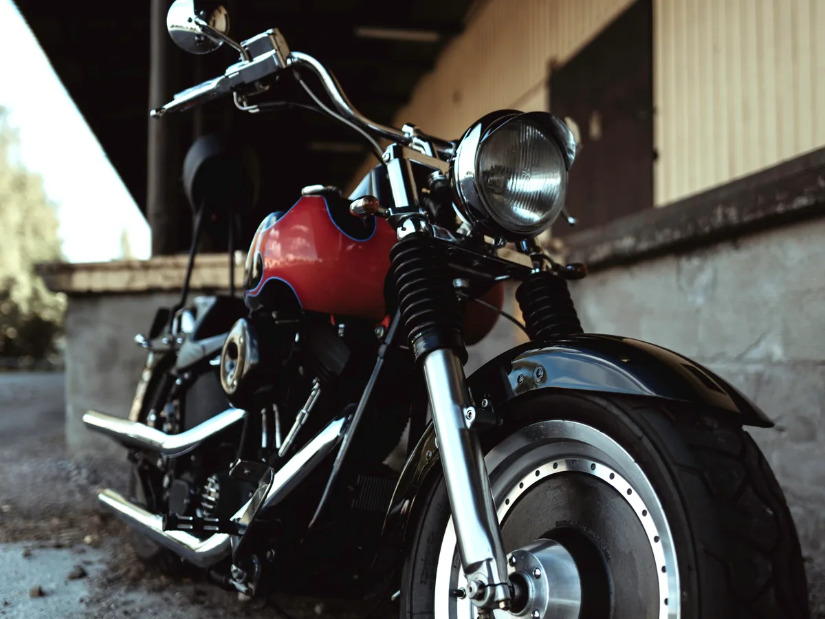 Moto custom limpa, com tanque vermelho e cromados brilhando depois da lavagem